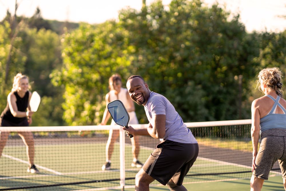 Group of residents at Arista San Gabriel playing pickleball